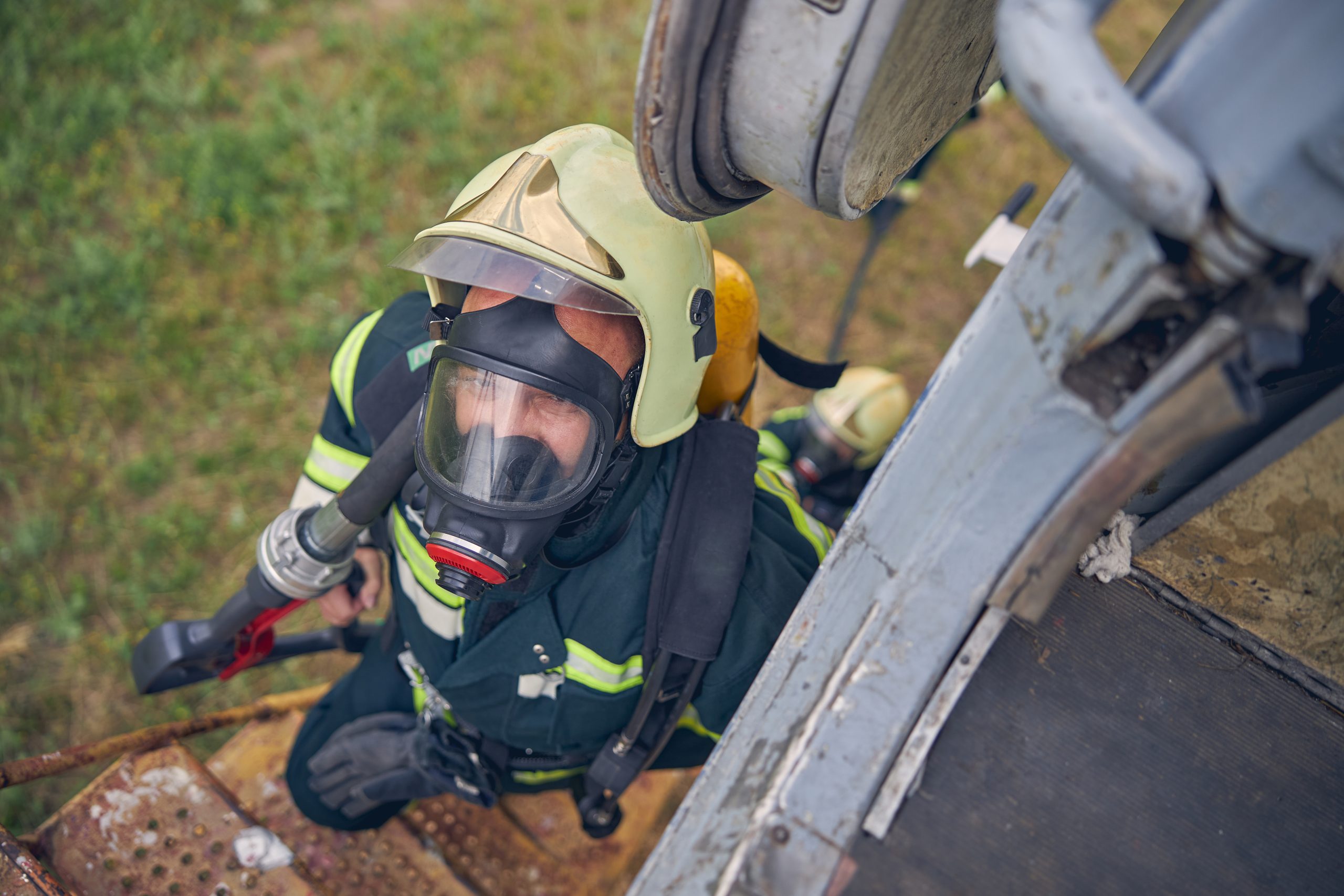 Top view portrait of firefighter in safe helmet going up on stairs with full equipment