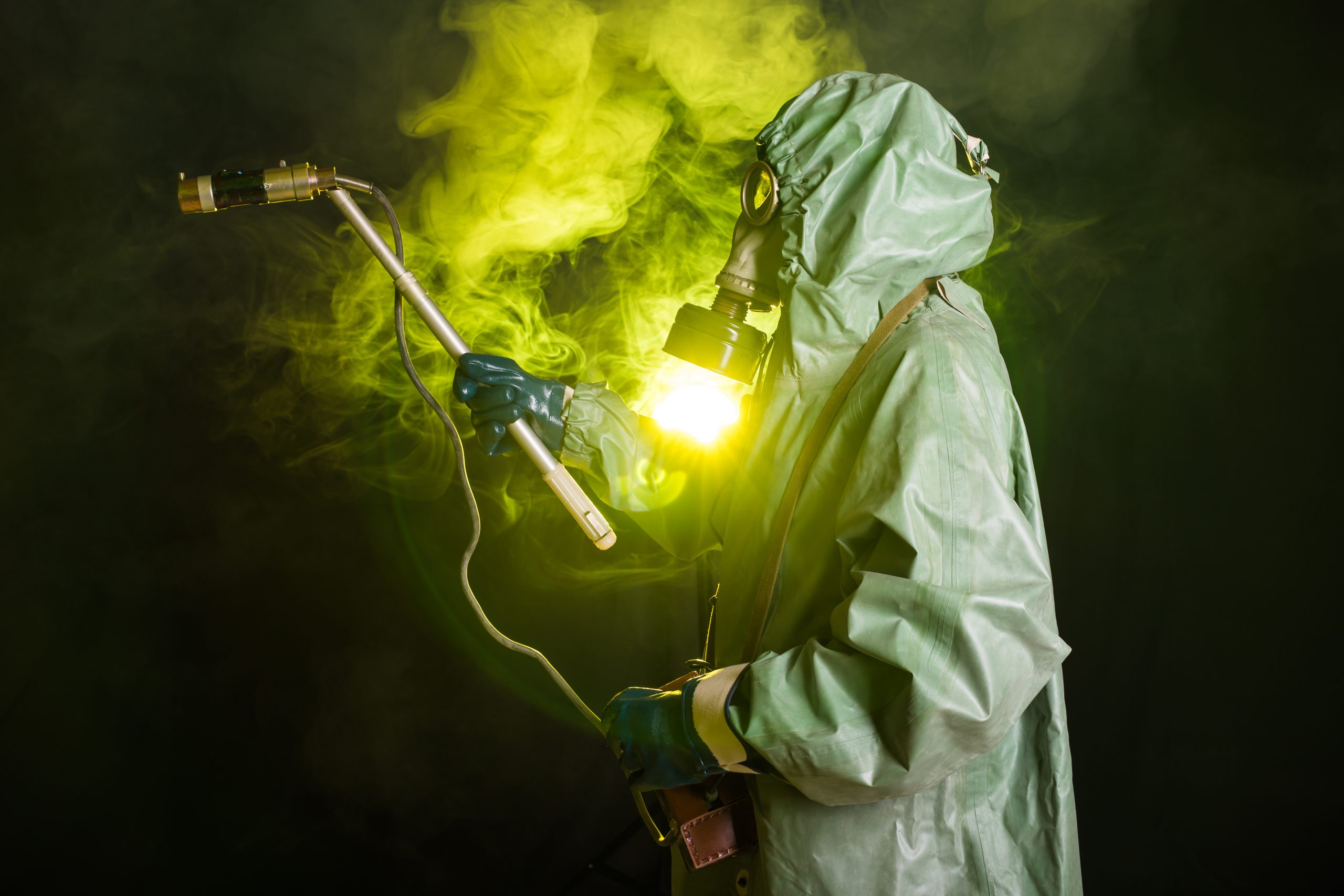 Man in the gas mask and chemical suit. The worker doing measure radioactivity